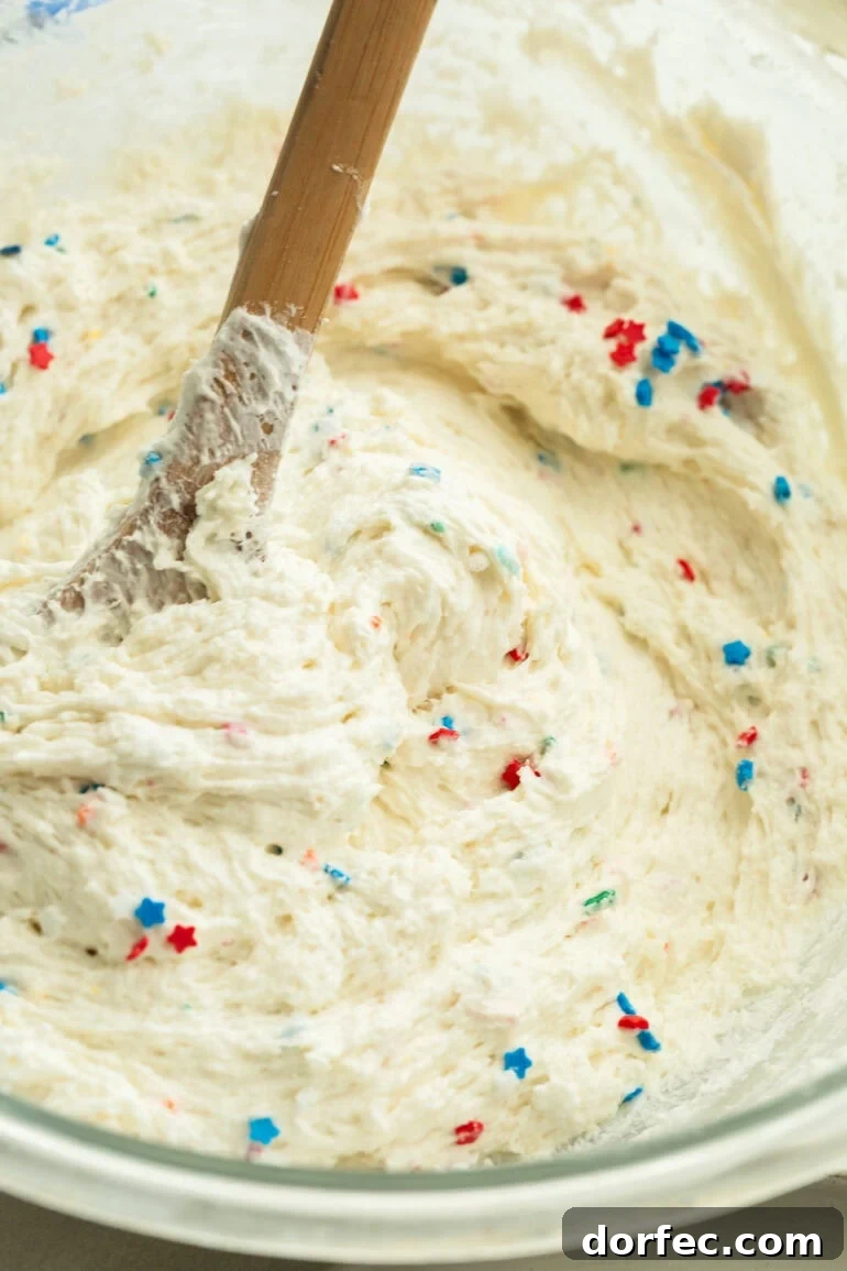 Close-up of creamy dessert dip topped with red white and blue sprinkles.