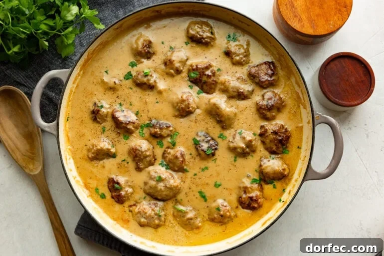 Authentic Swedish Meatballs with Creamy Gravy 7 a large dutch oven full of golden brown Swedish meatballs sitting in a thick gravy sauce