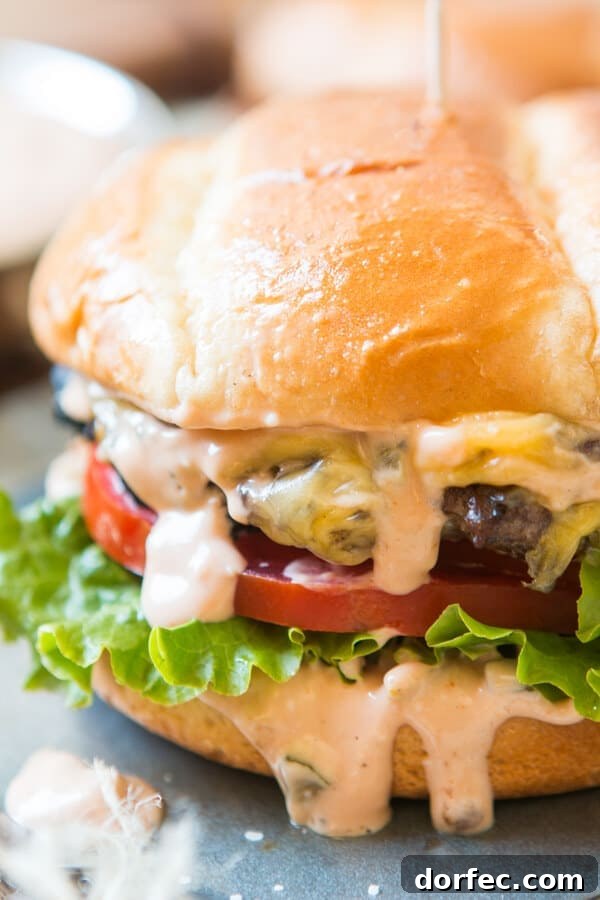 Ultimate Homemade Burger Sauce Recipe for Juicy Flavor 2 the best burger sauce dripping out the sides of a cheeseburger with golden bun, lettuce and tomatoes