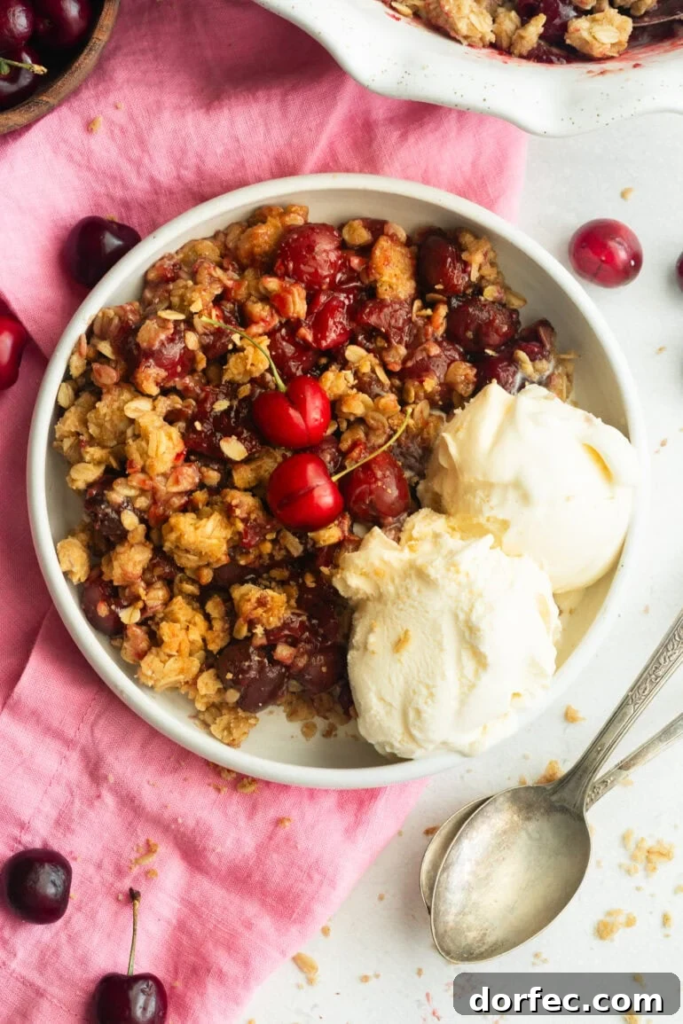 Homemade Old Fashioned Cherry Crisp Recipe 2 a serving of cherry crisp with oatmeal topping and two scoop of vanilla ice cream on the side