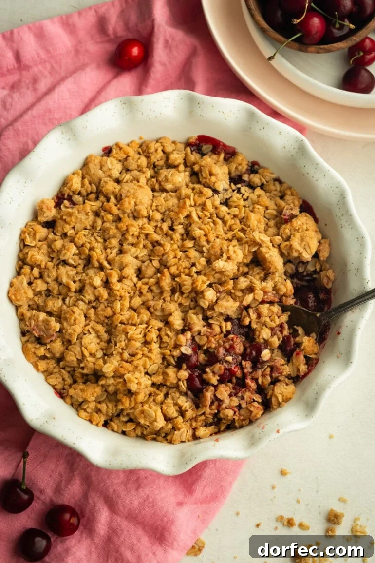 Homemade Old Fashioned Cherry Crisp Recipe 5 a circular white baking dish full of baked cherry crisp topped with golden oat topping